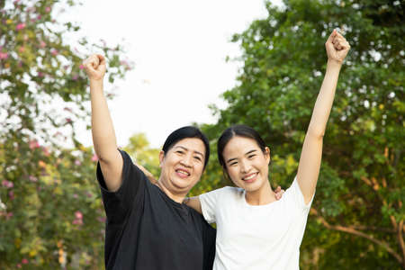 Healthy and strong senior mother staying in the park with asian young adult daughter, concept of family lifestyle, spring and summer wellness, family togetherness, mother and daughter, mother dayの写真素材