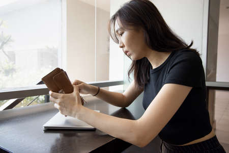 young Asian woman properly wearing face mask in working office, concept of taking precaution measure, social distancing, new normal lifestyle while waiting for coronavirus cure, COVID-19 vaccineの写真素材