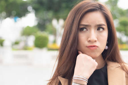 unhappy asian female office worker looking up, portrait of tired exhausted overworked business woman having problem with layoff, joblessness, unemployment, depressionの写真素材