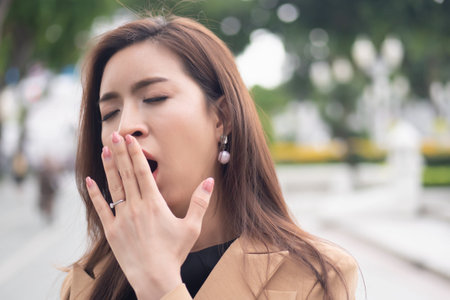 sleepy business woman yawning from overwork, stress, insomniaの写真素材