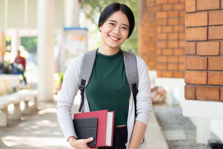 Excited asian woman college student giving thumb up while getting back to school after vaccination rollout program, header banner design with blank spaceの写真素材
