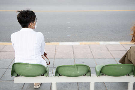 vaccinated middle aged woman still wearing mask in outdoor public space as covid coronavirus variant spreadの写真素材