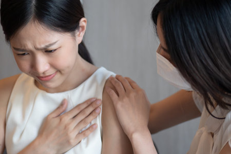 Vaccinated woman wearing face mask taking care of unvaccinated woman having pneumonia as symptomatic...