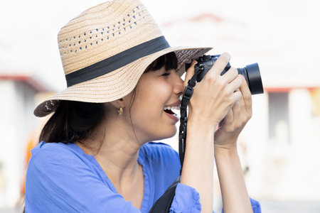 South American woman traveler taking travel photo, concept of summer vacation in reopened international tourism business, Asian travel destination in post pandemic worldの写真素材