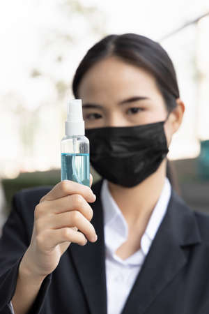 Vaccinated asian office worker or business woman wearing face mask even after getting her vaccine, concept of mask wearing, frequent hand wash and social distancing regardless of vaccination statusの写真素材