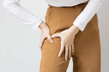 Asian woman suffering from pelvic pain, hip muscle stiffnessの写真素材