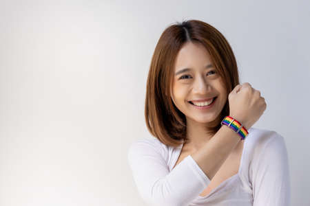 Confident asian LGBT woman wearing LGBTQ rainbow wristband, concept of gay pride month, lesbian pride, LGBT awareness movement, non-binary inclusivity and diversityの写真素材