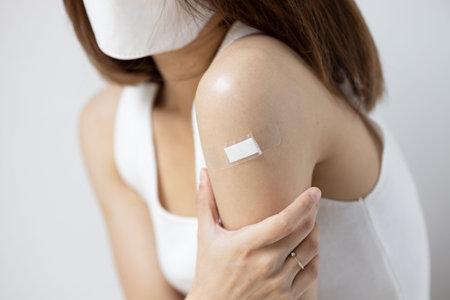Concept image of fully vaccinated asian woman wearing face mask with side effect from vaccine shot or long covidの写真素材