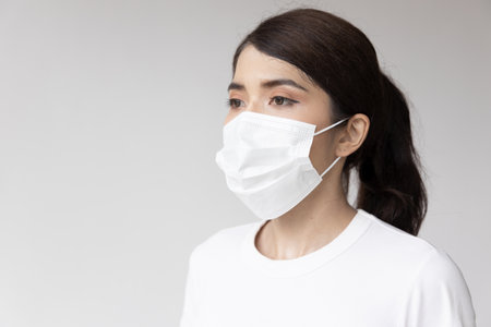 Asian woman wearing white face mask for seasonal flu and dust pollution protectionの写真素材