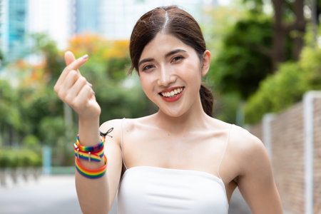Non-binary LGBT person showing loving heart hand sign for LGBT awareness pride monthの写真素材