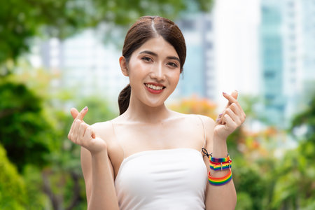 Non-binary LGBT person showing loving heart hand sign for LGBT awareness pride monthの写真素材