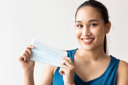 Woman happily taking off face mask, no more need to wear mask conceptの写真素材