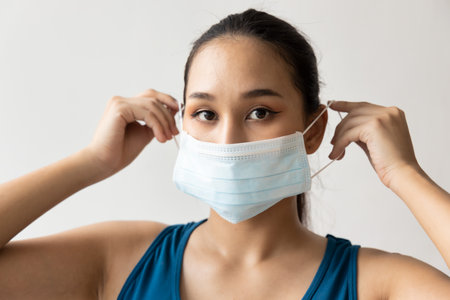 Woman wearing protective face mask for seasonal flu and dust pollution protectionの写真素材