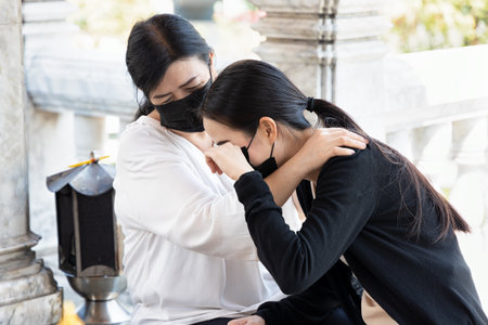 Sad daughter with understanding mother in religious serviceの写真素材