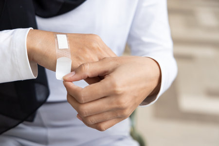 Wounded hand of woman, first aid treatment covering with clean bandage, closeup shotの写真素材