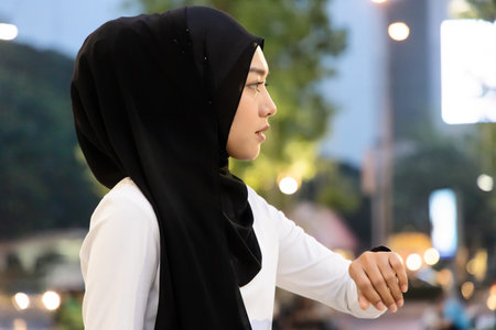 Unhappy muslim woman waiting for unpunctual people being late for an appointmentの写真素材