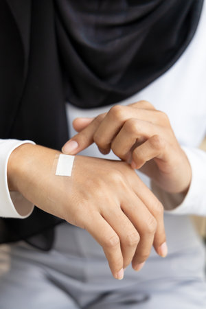 Wounded hand of woman, first aid treatment covering with clean bandage, closeup shotの写真素材