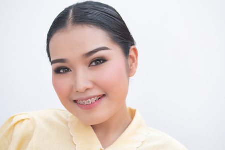 Happy smiling woman with teeth braces or orthodontics dental braces, cosmetic dental care concept imageの写真素材