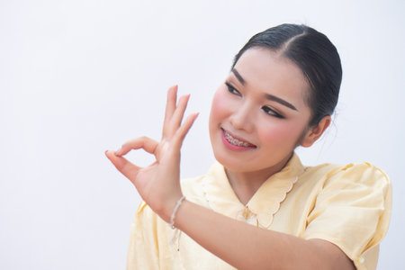 Woman pointing up accepting ok hand gesture to blank spaceの写真素材