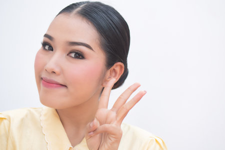 Confident asian plus size woman pointing up three fingers hand signの写真素材