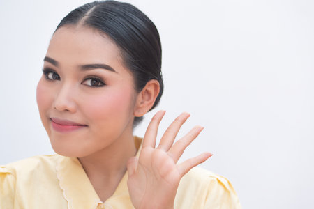 Confident asian plus size woman pointing up five fingers hand signの写真素材