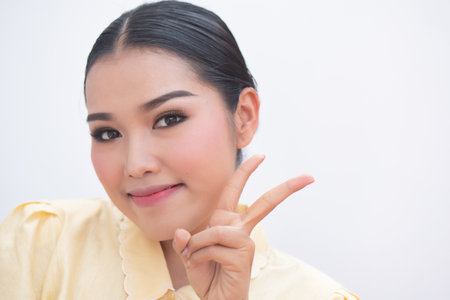 asian plus size woman pointing up confident two fingers sign, v for victoryの写真素材