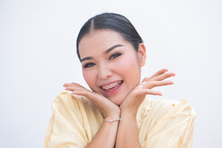 Exciting woman pointing at teeth braces or orthodontics dental braces, cosmetic dental care conceptの写真素材