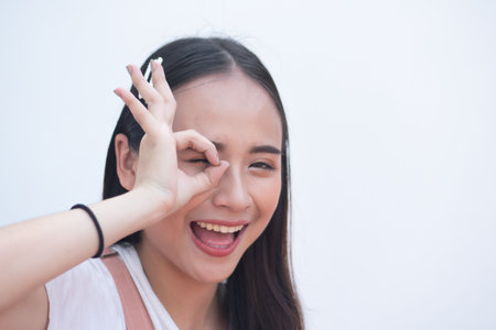 Woman pointing up accepting ok hand gesture to blank spaceの写真素材