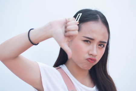 Woman pointing up disapproving thumb down hand gestureの写真素材