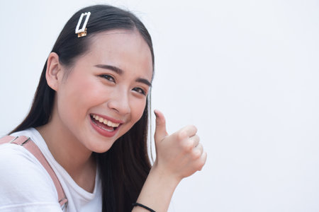 Woman pointing up approving thumb up hand gestureの写真素材