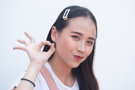 Woman pointing up accepting ok hand gesture to blank spaceの写真素材