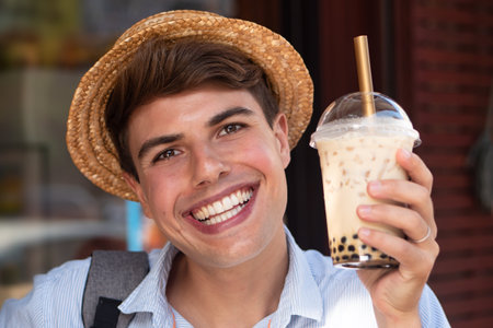 Happy man traveler drinking Asian boba milk teaの写真素材