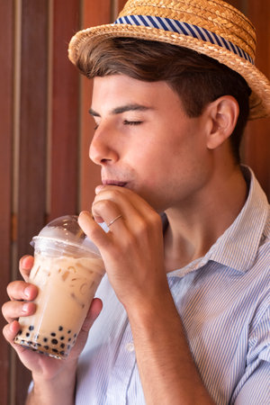 Happy man traveler drinking Asian boba milk teaの写真素材