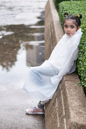Bored little girl waiting after the rainの写真素材