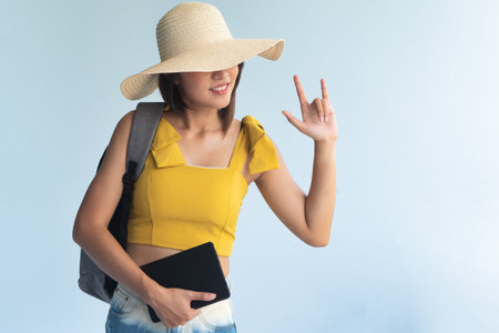 Exciting woman traveler pointing up ILY or rock hand signの写真素材