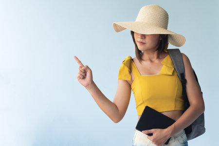 woman traveler pointing up to blank isolated spaceの写真素材