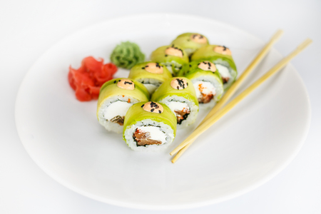 Japanese  seafood  sushi , roll and chopstick on a white plate with ginger and wasabiの写真素材