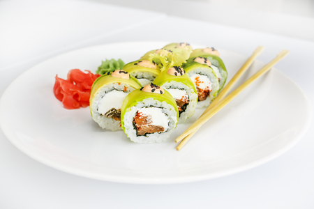 Japanese  seafood  sushi , roll and chopstick on a white plate with ginger and wasabiの写真素材