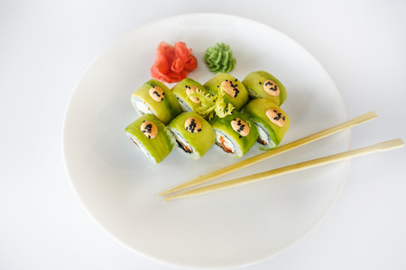 Japanese  seafood  sushi , roll and chopstick on a white plate with ginger and wasabiの写真素材