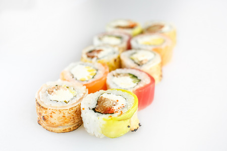 Sushi set. Rolls with salmon  and vegetables, vegetarian, on a wooden plate isolated on white backgroundの写真素材