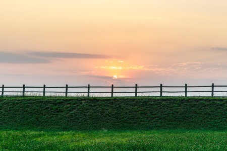fence, rural nature at sunset. Beautiful summer landscape with field  - Belarusの写真素材