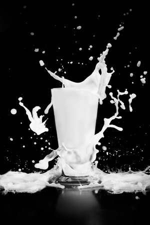 milk splash with glass on black backgroundの写真素材