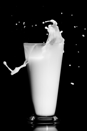 milk splash with glass on black backgroundの写真素材