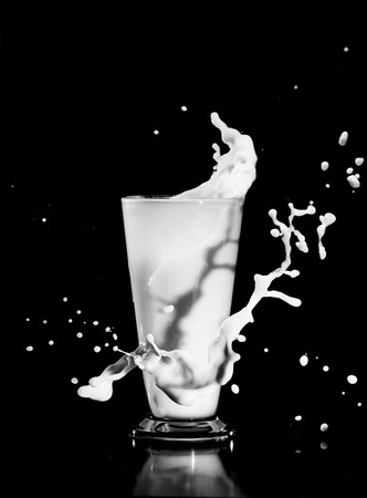 milk splash with glass on black backgroundの写真素材