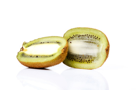 Slice of fresh kiwi fruit isolated on white background with reflectionの写真素材