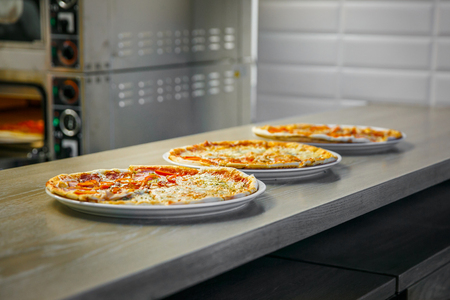 The process of making three pizzas on bar kitchenの写真素材