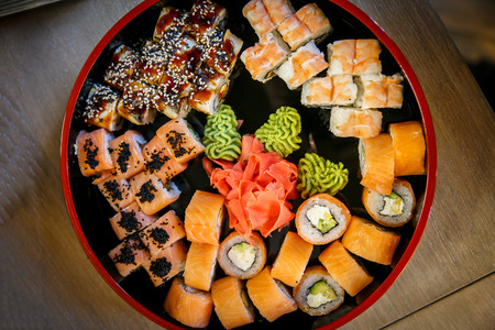 Sushi Set nigiri, rolls and sashimi served in traditional Japan black Sushioke round plateの写真素材