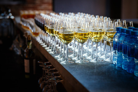 catering services. glasses with champagne or wine in row background at restaurant partyの写真素材
