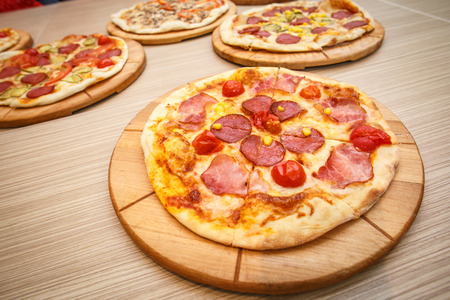 Colorful sliced pizza with mozzarella cheese, chicken, sweet corn, sweet pepper and parsley close up top view.の写真素材