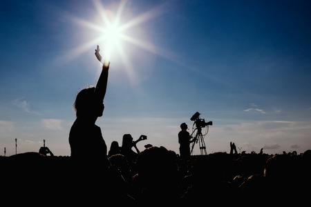 Girl enjoying the music festival concert, black silhouette, with recording mobile phoneの写真素材